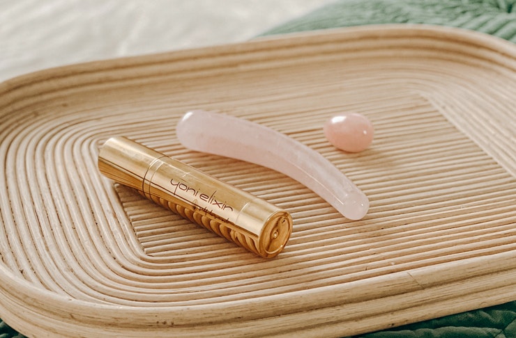 rose quartz crystal sex toys on a wooden tray